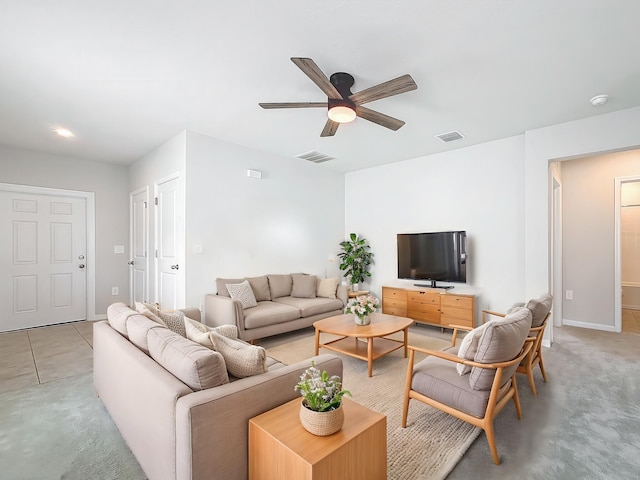 living room with light colored carpet, visible vents, ceiling fan, and baseboards