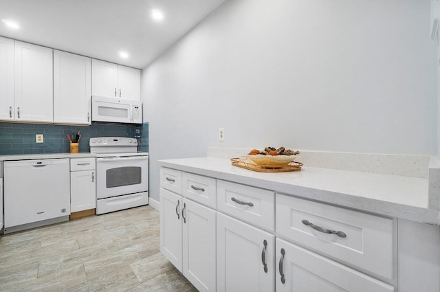 kitchen with white appliances, recessed lighting, decorative backsplash, and white cabinets