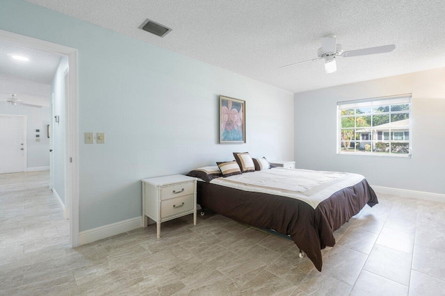 bedroom with visible vents, a ceiling fan, light tile patterned flooring, a textured ceiling, and baseboards