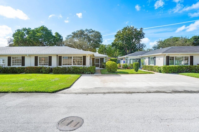 single story home featuring a front lawn and brick siding