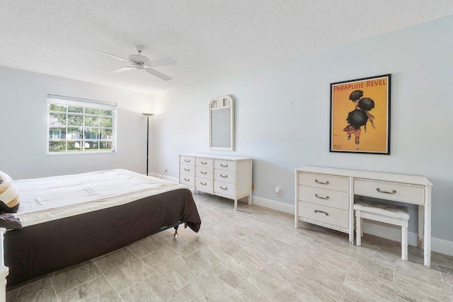 bedroom with a ceiling fan, a textured ceiling, and baseboards