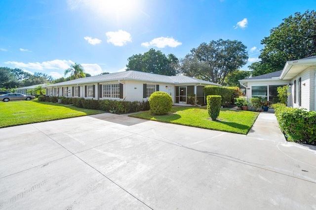 ranch-style house featuring driveway and a front yard