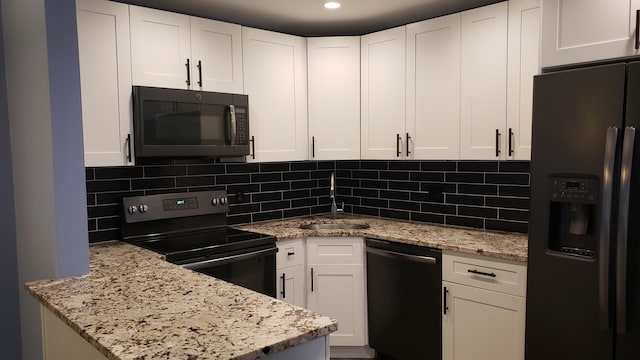 kitchen featuring white cabinetry, a sink, black appliances, and light stone countertops