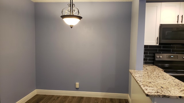 dining area featuring baseboards and dark wood-type flooring