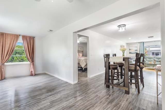 dining space featuring ceiling fan, wood finished floors, visible vents, and baseboards