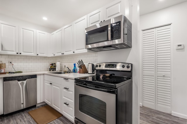 kitchen featuring dark wood-style floors, stainless steel appliances, light countertops, and white cabinetry