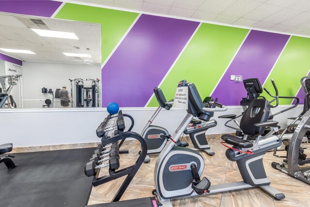 gym with a drop ceiling and visible vents