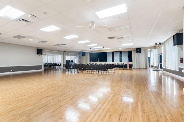 exercise area featuring visible vents, ceiling fan, baseboards, and wood finished floors