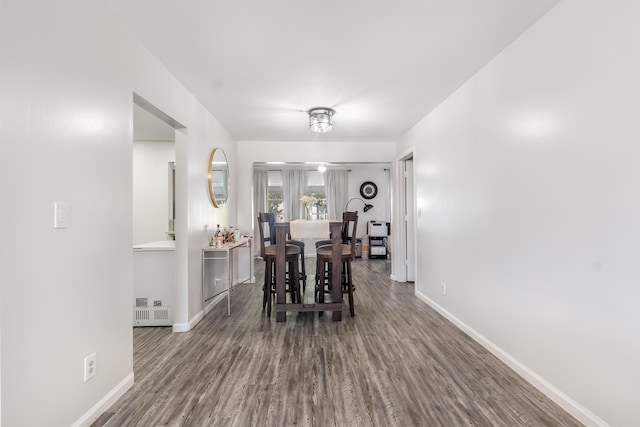 dining space featuring visible vents, baseboards, and dark wood finished floors