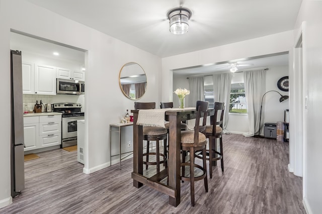 dining area with ceiling fan, baseboards, and wood finished floors