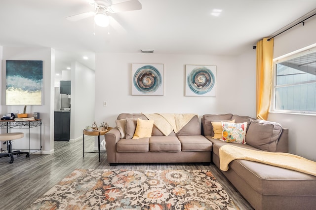 living area with visible vents, ceiling fan, baseboards, and wood finished floors