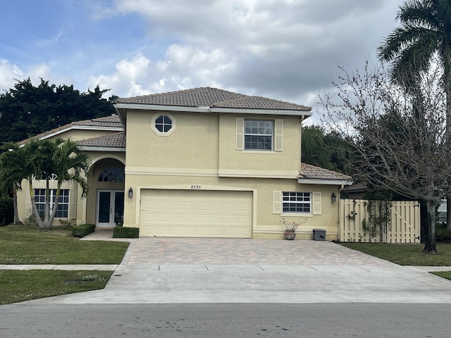 view of front of house featuring decorative driveway, french doors, stucco siding, an attached garage, and a tiled roof