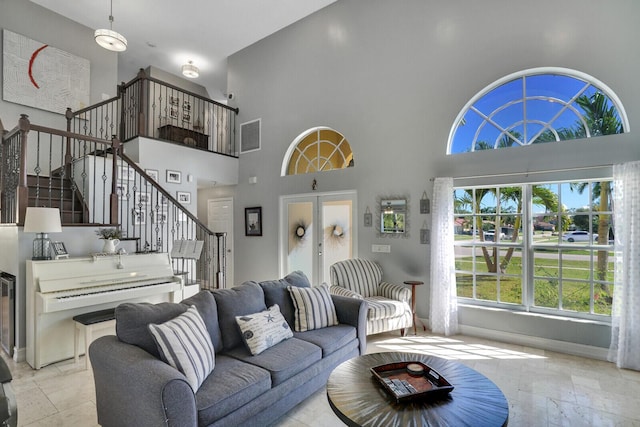 living area with french doors, stairway, visible vents, and baseboards