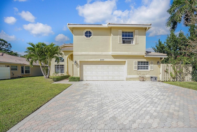 view of front of home with fence, a tiled roof, decorative driveway, stucco siding, and a front lawn