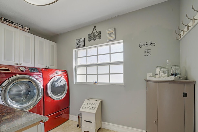 laundry room featuring washing machine and dryer, cabinet space, and baseboards