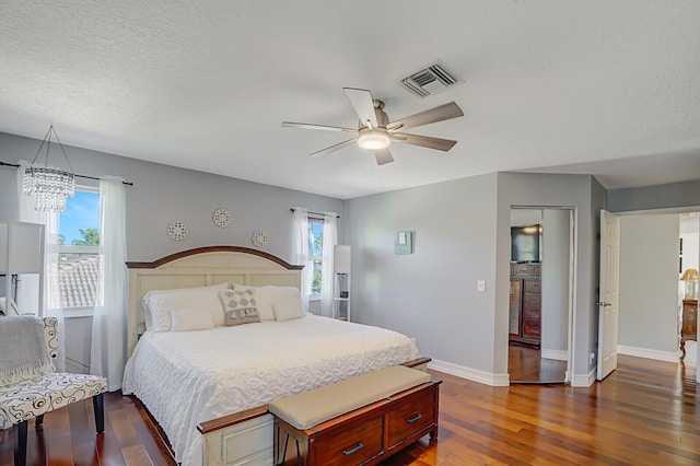 bedroom with multiple windows, dark wood-style flooring, visible vents, and baseboards