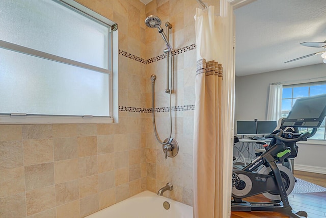 bathroom featuring ceiling fan, shower / bath combo, and wood finished floors