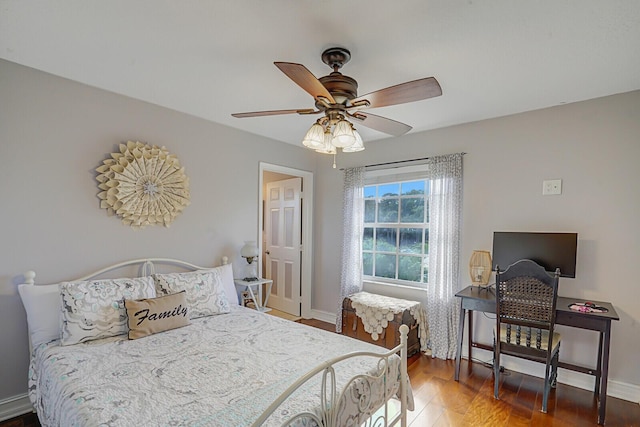 bedroom with ceiling fan, baseboards, and wood finished floors