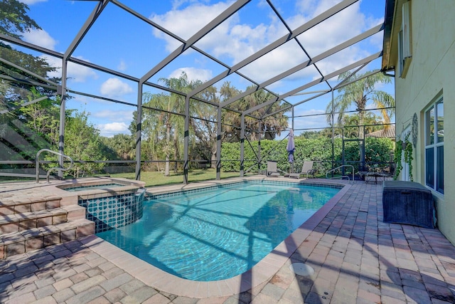 view of swimming pool featuring glass enclosure, a patio area, and a pool with connected hot tub