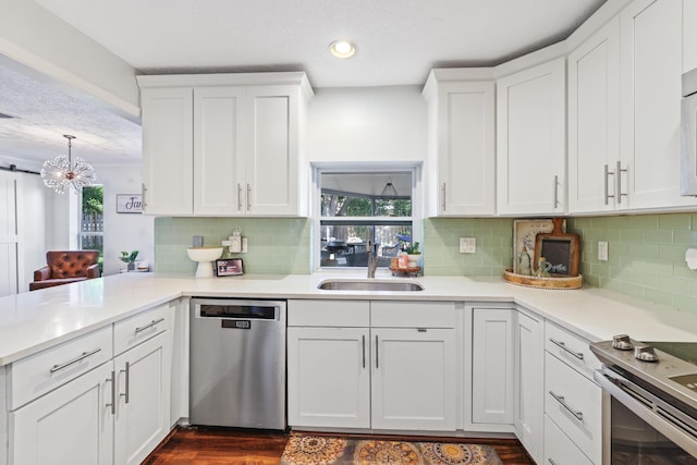 kitchen featuring dishwasher, light countertops, a sink, and white cabinetry