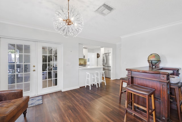 dining space featuring baseboards, visible vents, dark wood-style floors, ornamental molding, and french doors