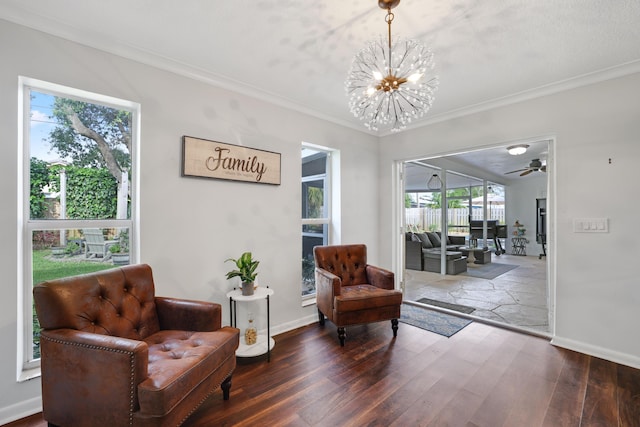 sitting room with ornamental molding, dark wood-type flooring, baseboards, and a notable chandelier