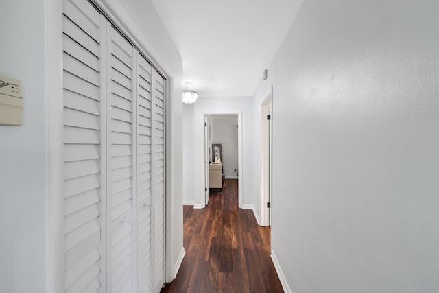 hall featuring dark wood-style flooring and baseboards