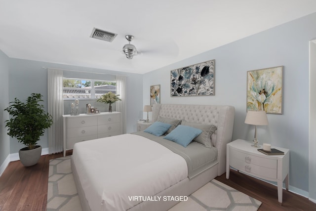 bedroom featuring visible vents, baseboards, and wood finished floors