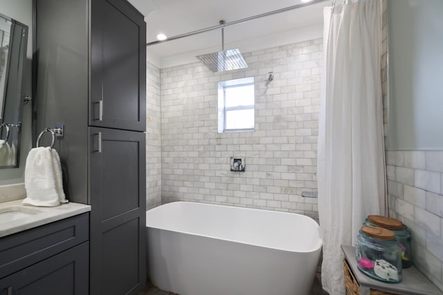 full bathroom with curtained shower, a tub, tile walls, and vanity