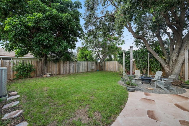 view of yard featuring a patio area, a fenced backyard, and a fire pit