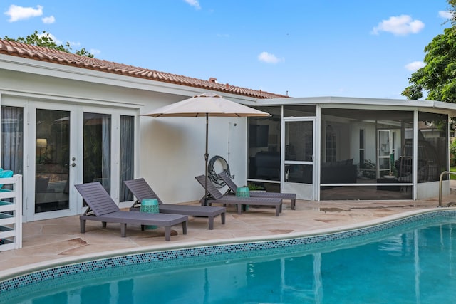 back of house with a tile roof, a patio, stucco siding, a sunroom, and an outdoor pool