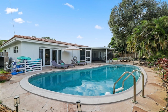 view of swimming pool with a fenced in pool, a patio, a sunroom, fence, and french doors