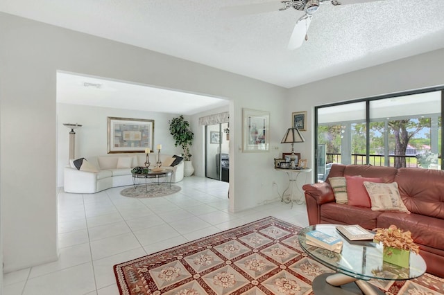 living room featuring light tile patterned floors, a textured ceiling, and a ceiling fan