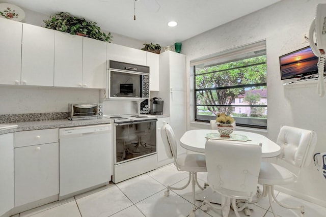 kitchen with light tile patterned flooring, a toaster, recessed lighting, white appliances, and white cabinets