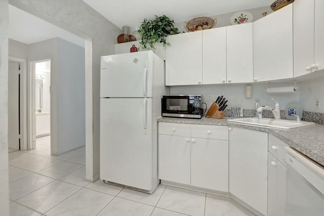 kitchen featuring light tile patterned floors, white appliances, a sink, white cabinets, and light countertops