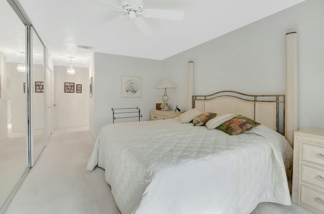 bedroom with light carpet, ceiling fan, and visible vents