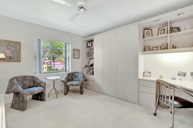 living area featuring light carpet, ceiling fan, and a textured ceiling