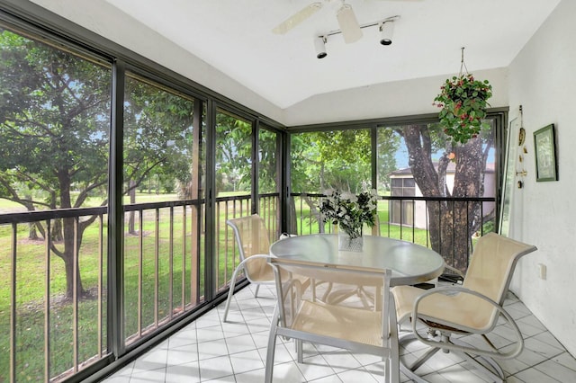 sunroom / solarium featuring lofted ceiling, rail lighting, and a ceiling fan