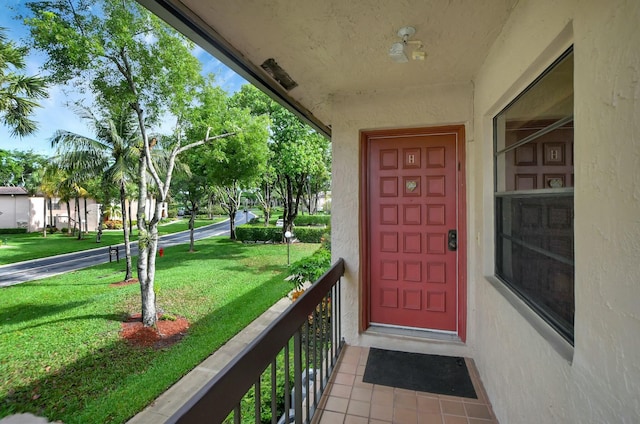 entrance to property with a yard and stucco siding