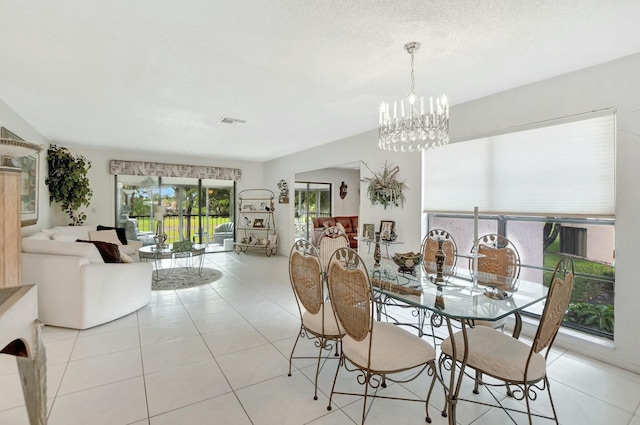 dining area featuring visible vents, a chandelier, a textured ceiling, and light tile patterned flooring