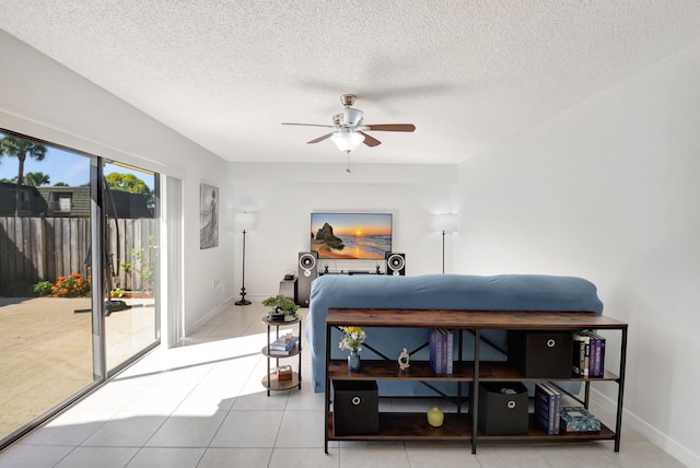 bedroom with a textured ceiling, baseboards, tile patterned flooring, ceiling fan, and access to outside