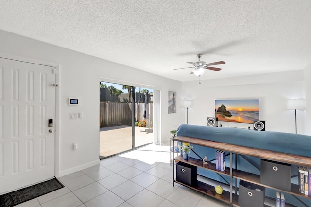 bedroom featuring light tile patterned floors, baseboards, a textured ceiling, and access to exterior