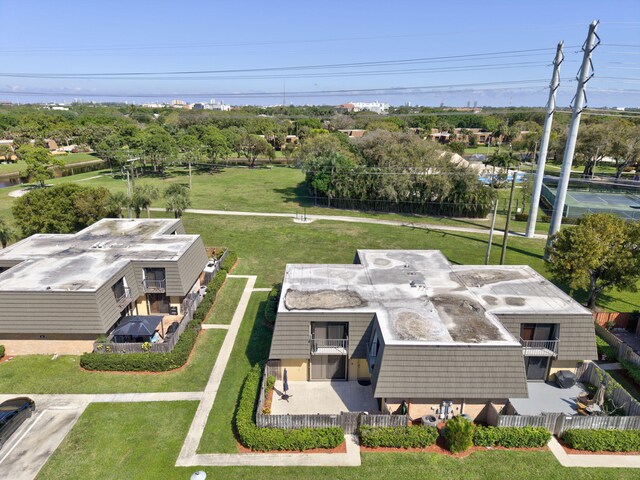 3717 37th Way, West Palm Beach, FL 33407 - view of front facade featuring mansard roof, a balcony, brick siding, and a fenced front yard