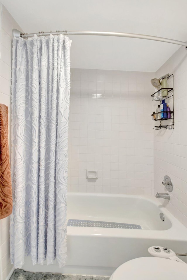 bathroom featuring toilet and shower / bath combo