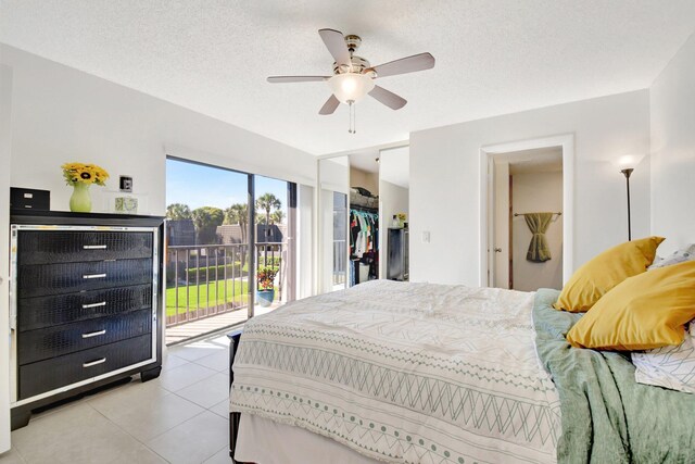 bedroom with a textured ceiling, ceiling fan, light tile patterned flooring, and access to exterior