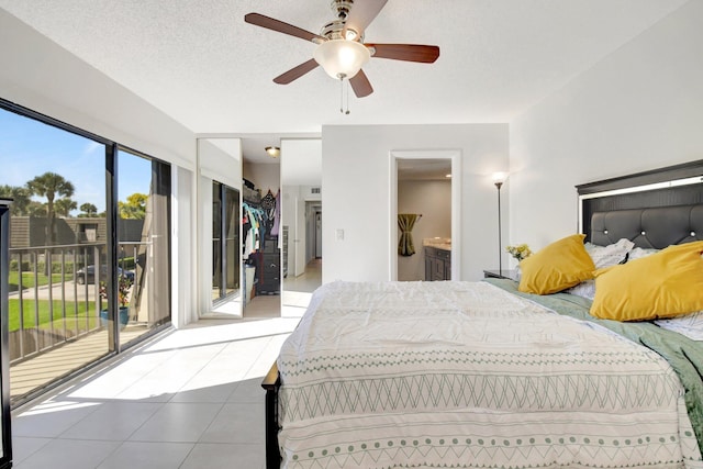 bedroom featuring a textured ceiling, ceiling fan, access to outside, tile patterned floors, and ensuite bath