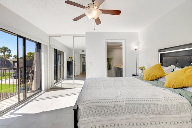 tiled bedroom with access to exterior, ensuite bath, and ceiling fan