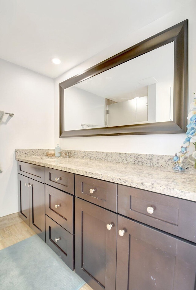 bathroom featuring baseboards, wood finished floors, and vanity