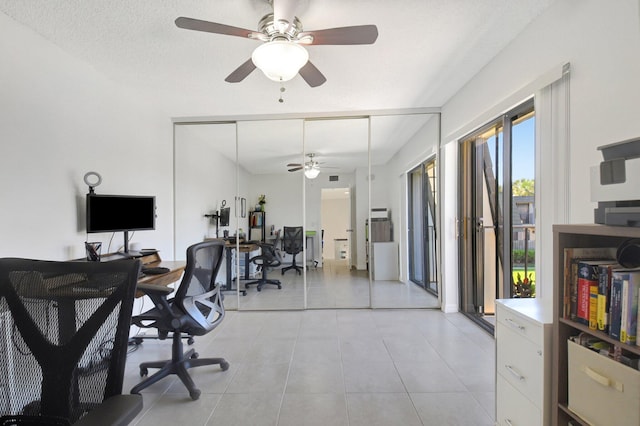 home office with light tile patterned floors and a ceiling fan