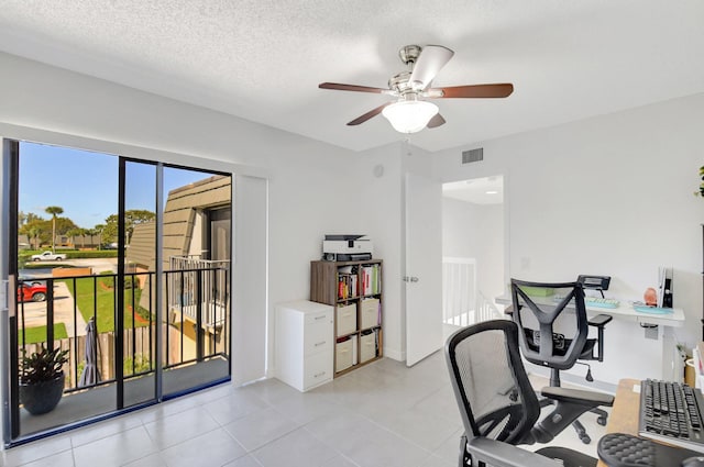 office with light tile patterned floors, ceiling fan, visible vents, and a textured ceiling